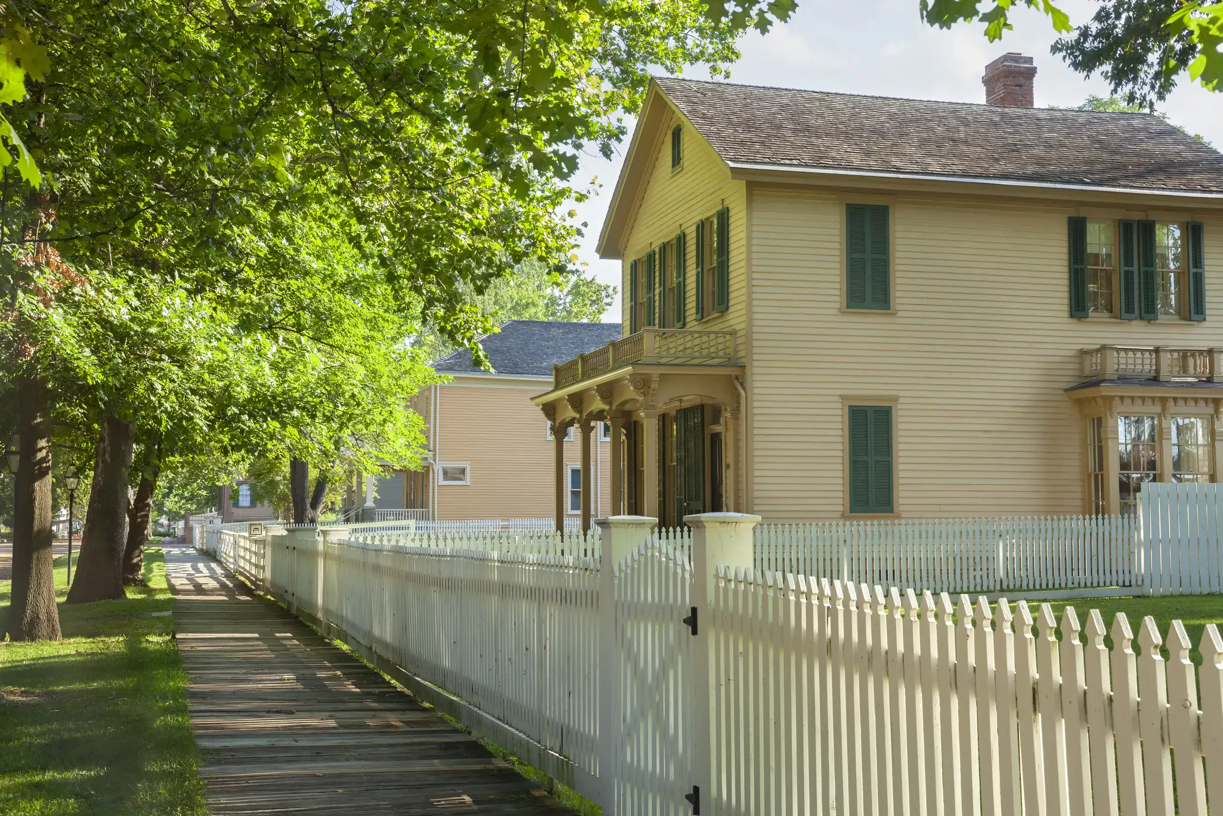 A wooden white fence on a suburban house.