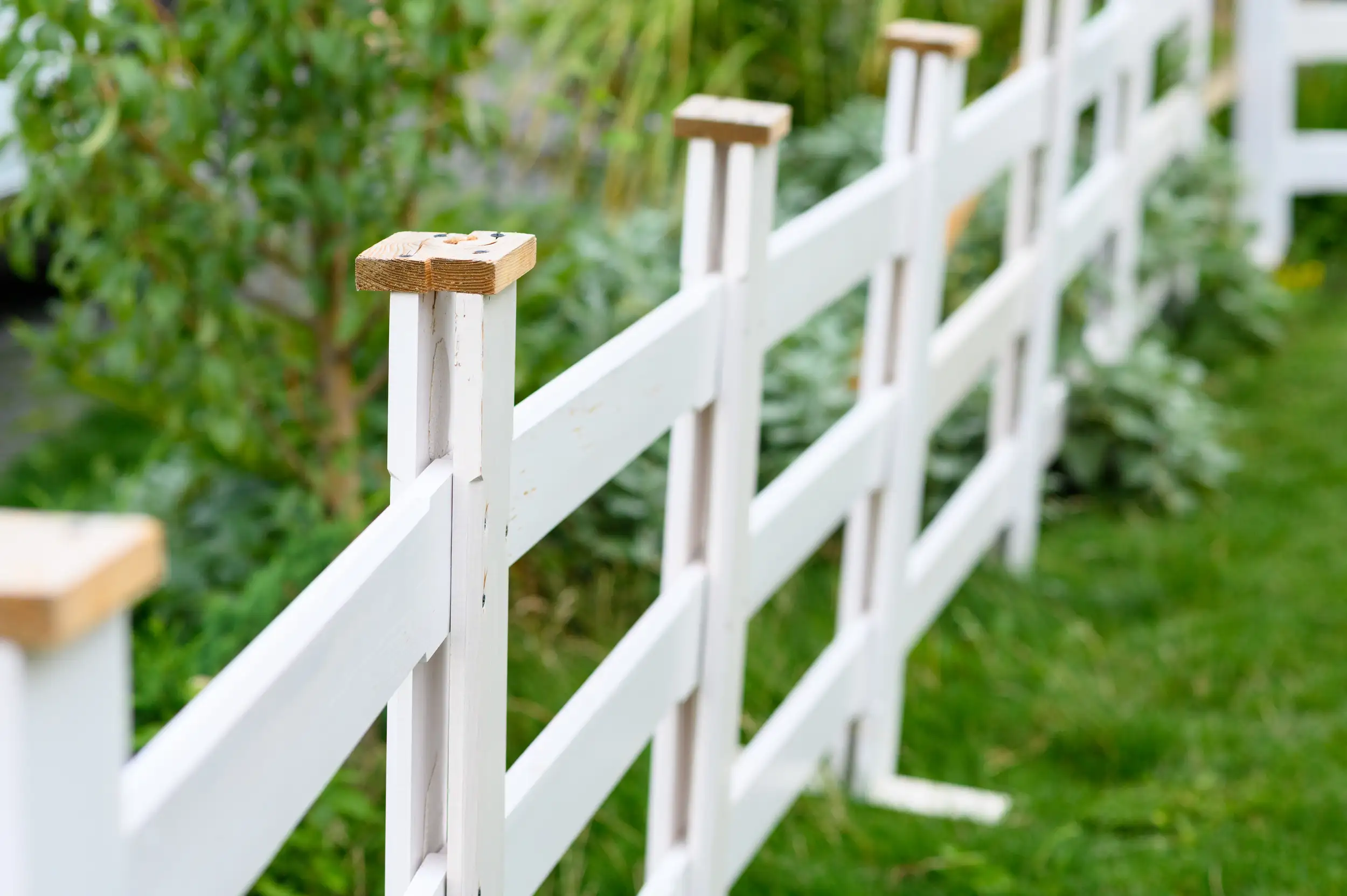 A zoomed image of a wooden white fence.